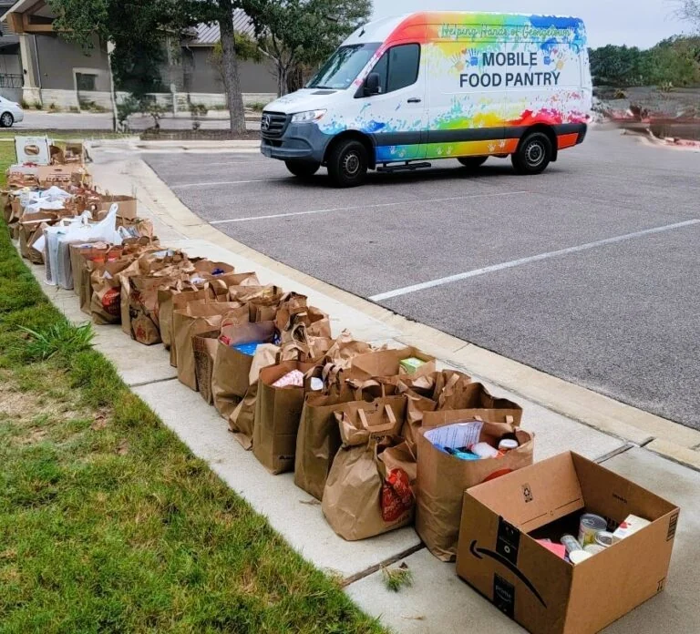 The Helping Hands Mobile Food Pantry van with rows of grocery bags ready for distribution